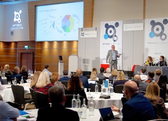 Delegates sitting at tables, within a conference