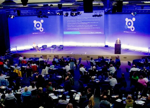 Delegates sitting at tables, within a conference
